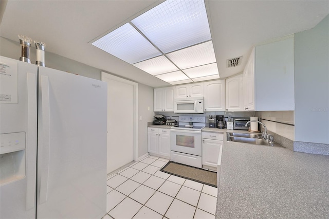 kitchen with sink, light tile patterned floors, white appliances, and white cabinetry