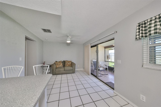 dining room featuring ceiling fan, light tile patterned floors, plenty of natural light, and a textured ceiling