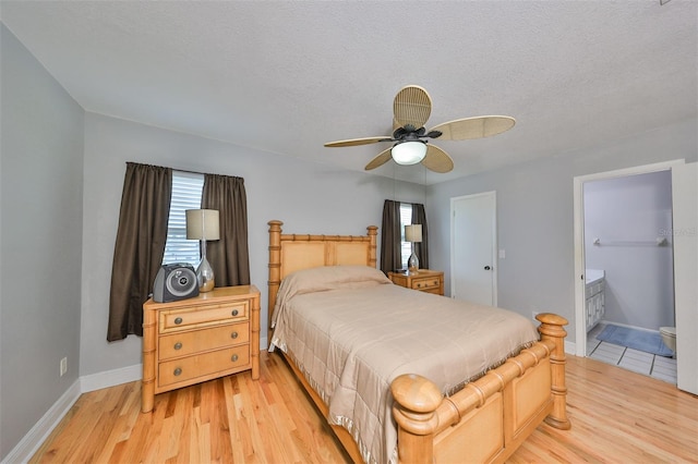 bedroom featuring a textured ceiling, connected bathroom, ceiling fan, and light hardwood / wood-style floors