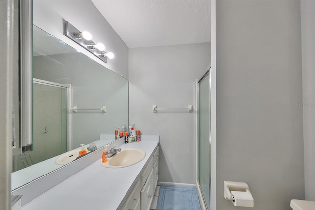 bathroom featuring tile patterned flooring, walk in shower, toilet, vanity, and a textured ceiling