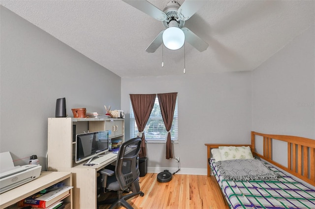 bedroom featuring light wood-type flooring, a textured ceiling, and ceiling fan