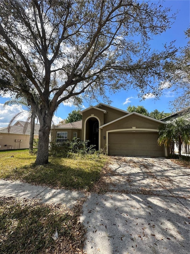 view of front of house with driveway, an attached garage, and stucco siding