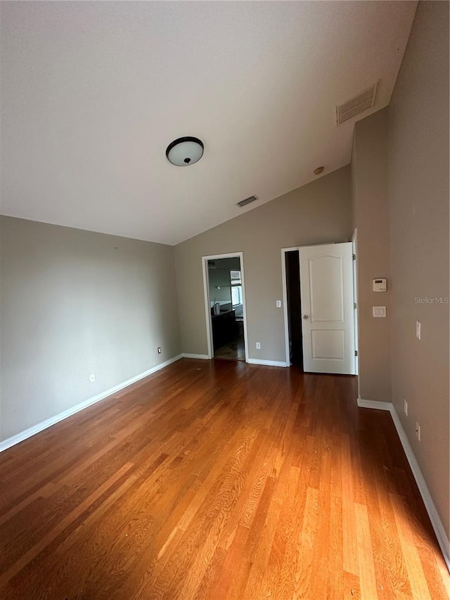 unfurnished bedroom with lofted ceiling, light wood finished floors, visible vents, and baseboards