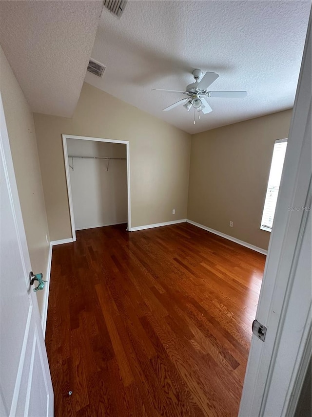 unfurnished bedroom featuring a closet, wood finished floors, visible vents, and baseboards