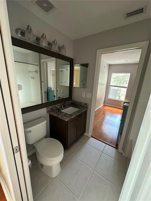 bathroom with toilet, tile patterned flooring, visible vents, and vanity