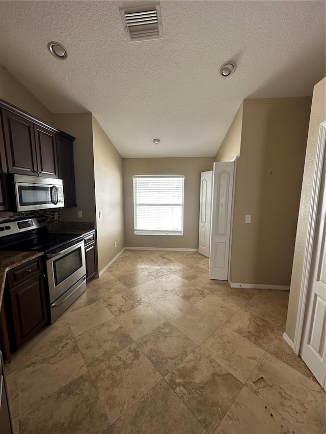 kitchen with baseboards, visible vents, dark countertops, appliances with stainless steel finishes, and dark brown cabinets