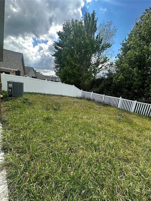 view of yard featuring fence and cooling unit