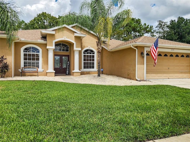 view of front of property with a garage, french doors, and a front lawn