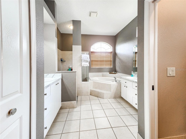 bathroom with tile patterned floors, separate shower and tub, a textured ceiling, and vanity