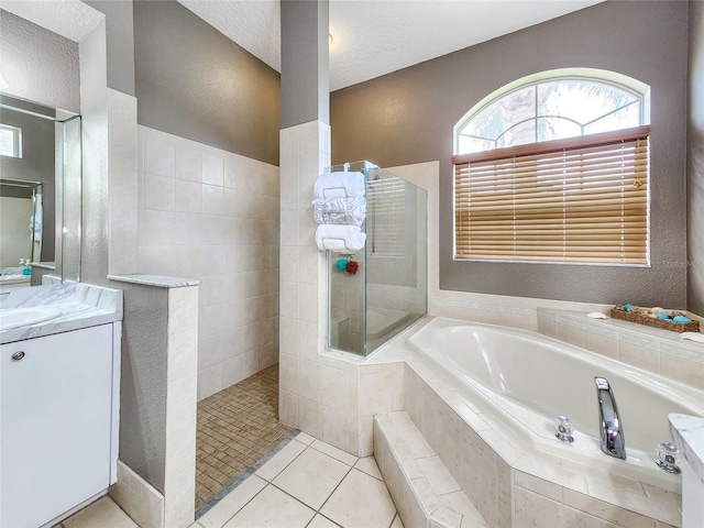 bathroom with vanity, a textured ceiling, separate shower and tub, and tile patterned floors