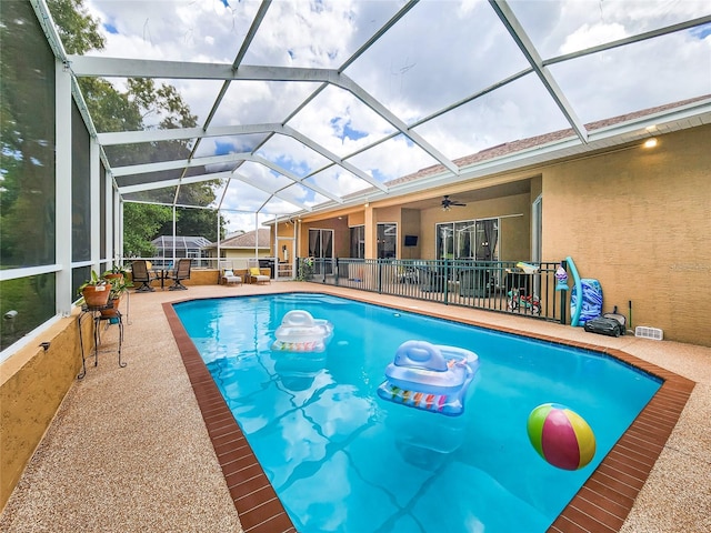 view of swimming pool with ceiling fan, a patio, and a lanai