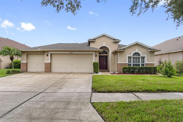 ranch-style home with a garage and a front lawn