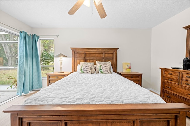 bedroom featuring access to outside, a textured ceiling, ceiling fan, and light hardwood / wood-style floors