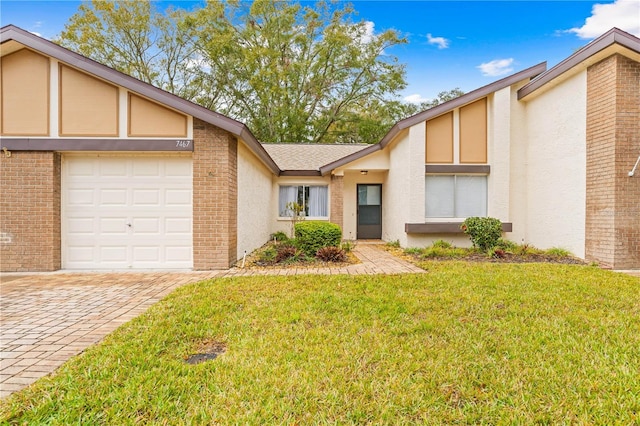 view of front of home with a garage and a front lawn