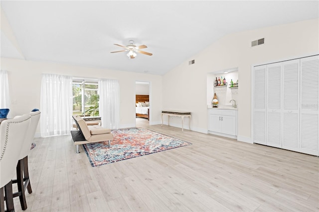 living room with lofted ceiling, sink, ceiling fan, and light wood-type flooring