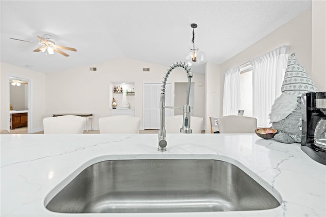 details featuring sink, decorative light fixtures, a textured ceiling, ceiling fan, and light stone countertops