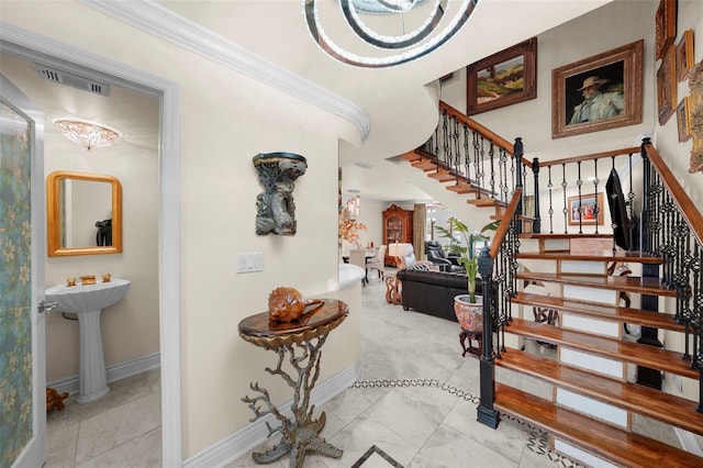 stairs with baseboards, visible vents, ornamental molding, and marble finish floor