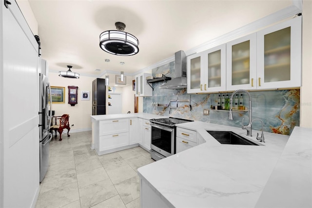kitchen featuring light stone countertops, appliances with stainless steel finishes, wall chimney exhaust hood, a peninsula, and backsplash