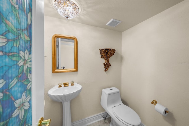 bathroom featuring visible vents, baseboards, toilet, and a shower with curtain
