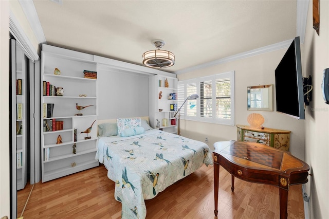 bedroom featuring crown molding and light wood-style flooring