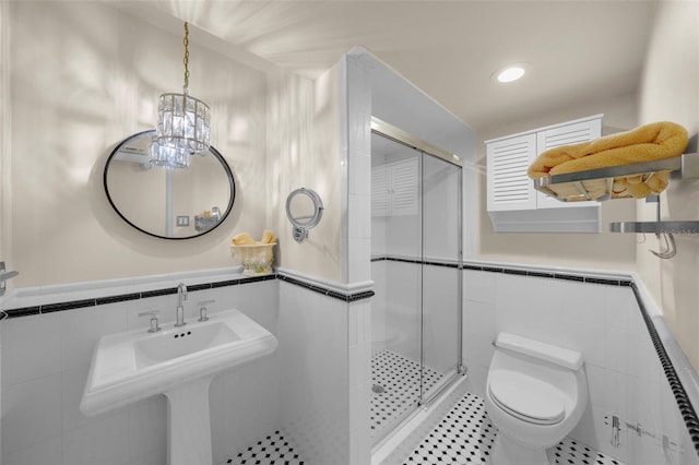 bathroom with a stall shower, toilet, and tile walls