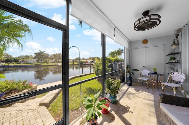 sunroom featuring a water view