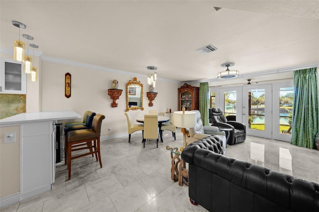 living area featuring visible vents, baseboards, crown molding, and french doors