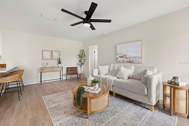 living room featuring light wood-type flooring and ceiling fan