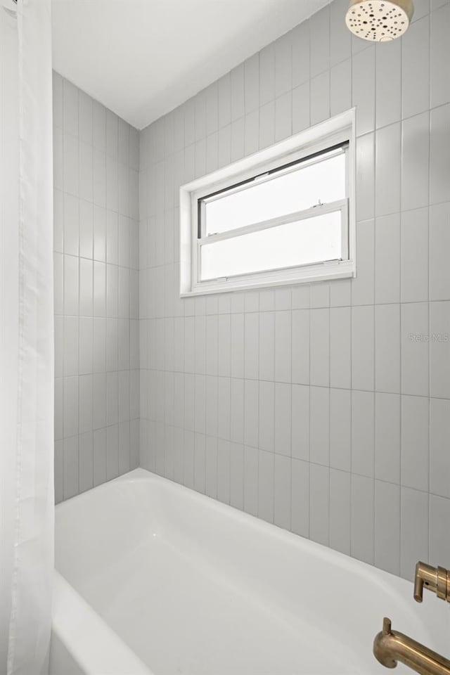 bathroom with shower / bath combo with shower curtain