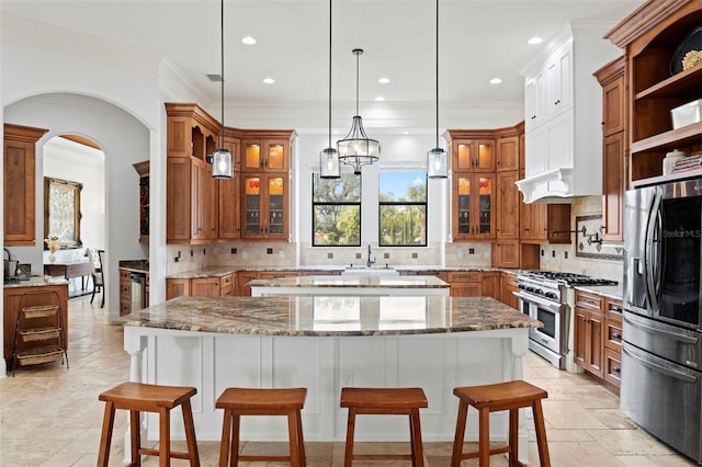 kitchen featuring a spacious island, a breakfast bar area, appliances with stainless steel finishes, and tasteful backsplash