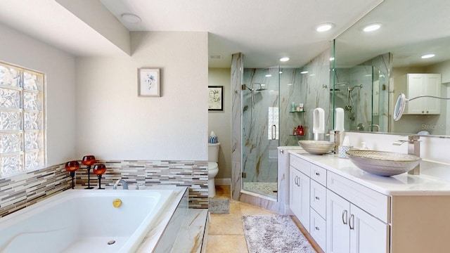 411 Harbor View Ln, Largo, FL 33770 - bathroom featuring a bath, a shower stall, double vanity, tile patterned floors, and toilet