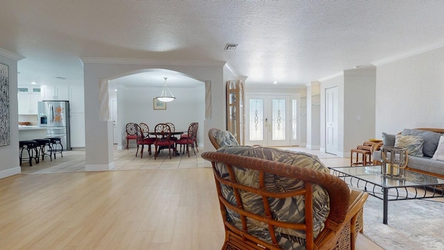 411 Harbor View Ln, Largo, FL 33770 - living area with arched walkways, ornamental molding, light wood-type flooring, baseboards, and a textured ceiling