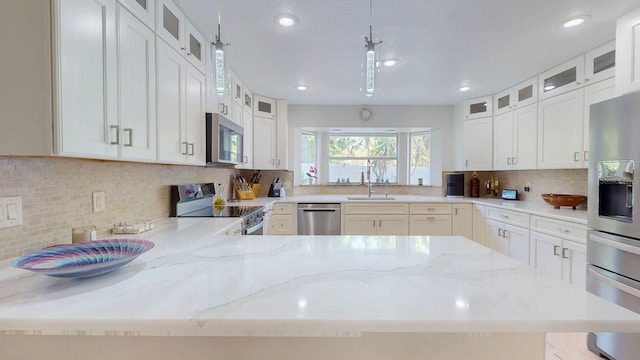 411 Harbor View Ln, Largo, FL 33770 - kitchen with appliances with stainless steel finishes, light stone counters, backsplash, a sink, and recessed lighting