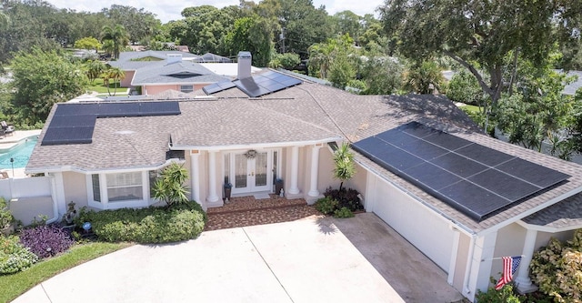 411 Harbor View Ln, Largo, FL 33770 - view of front of house with french doors, roof with shingles, solar panels, and stucco siding