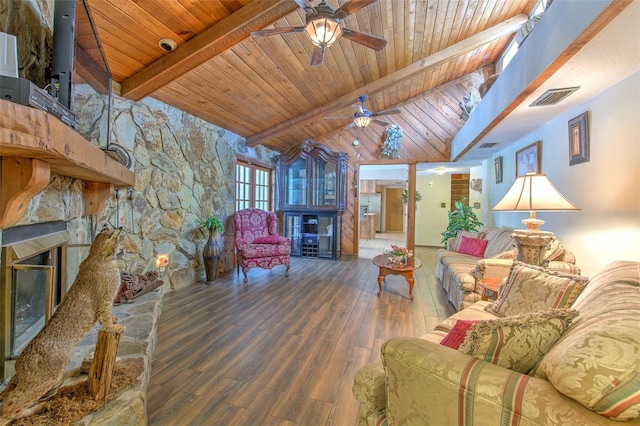 living room featuring wood ceiling, a stone fireplace, ceiling fan, hardwood / wood-style flooring, and vaulted ceiling with beams