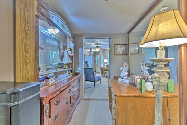 home office with a textured ceiling, ceiling fan, and light colored carpet