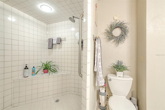 bathroom with toilet and a tile shower