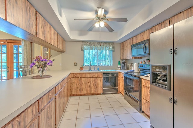 kitchen featuring black appliances, a tray ceiling, ceiling fan, and plenty of natural light