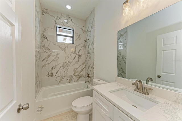 full bathroom with vanity, tiled shower / bath combo, and toilet