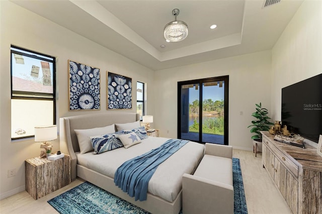 bedroom with a notable chandelier, a tray ceiling, and access to exterior