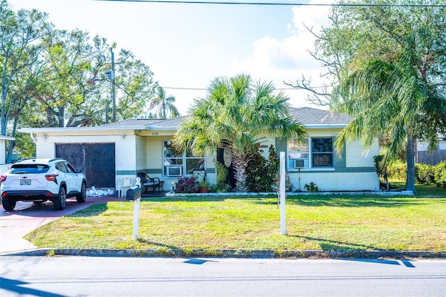 single story home featuring a front yard and a garage