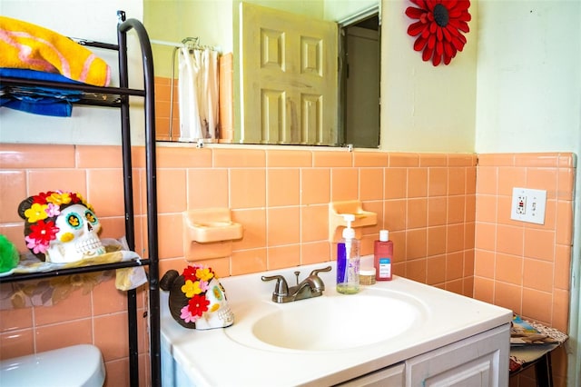 bathroom with backsplash, vanity, toilet, and tile walls