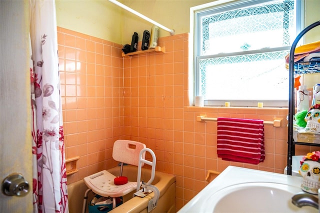 bathroom with shower / tub combo with curtain and tile walls