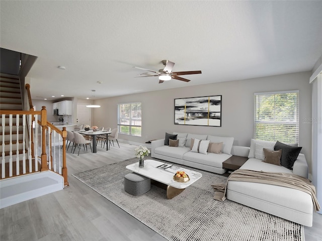 living room with light hardwood / wood-style flooring and ceiling fan