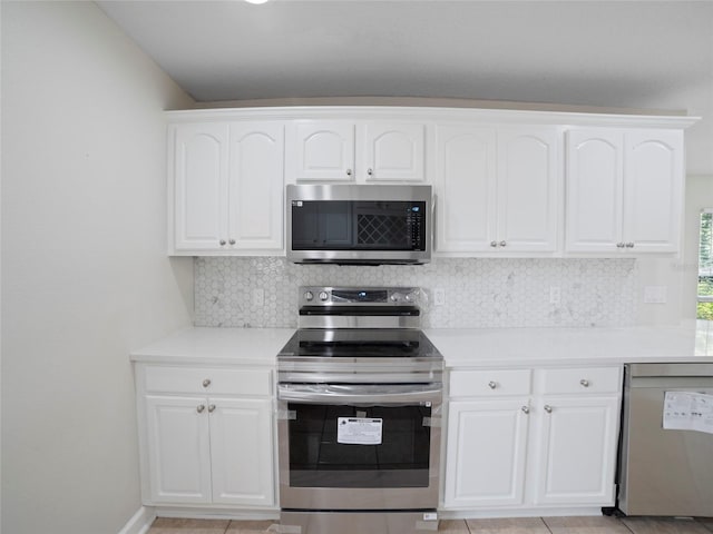 kitchen with stainless steel appliances, decorative backsplash, and white cabinetry