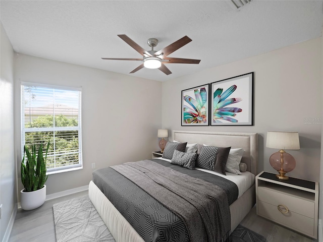 bedroom with ceiling fan and light wood-type flooring