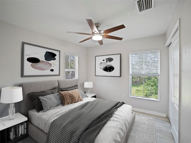 bedroom with ceiling fan and light hardwood / wood-style floors