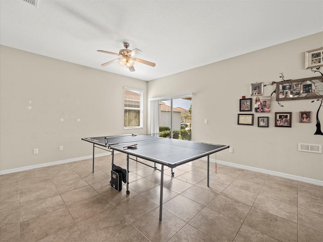 recreation room featuring light tile patterned flooring, a textured ceiling, and ceiling fan