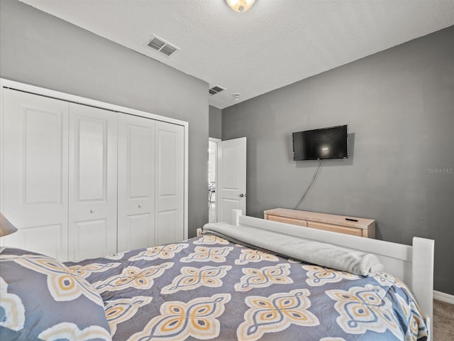 bedroom featuring a closet, carpet, and a textured ceiling