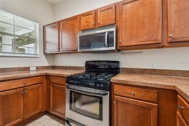 kitchen featuring appliances with stainless steel finishes and light tile patterned floors